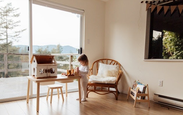 A little girl inside her room with sliding glass doors