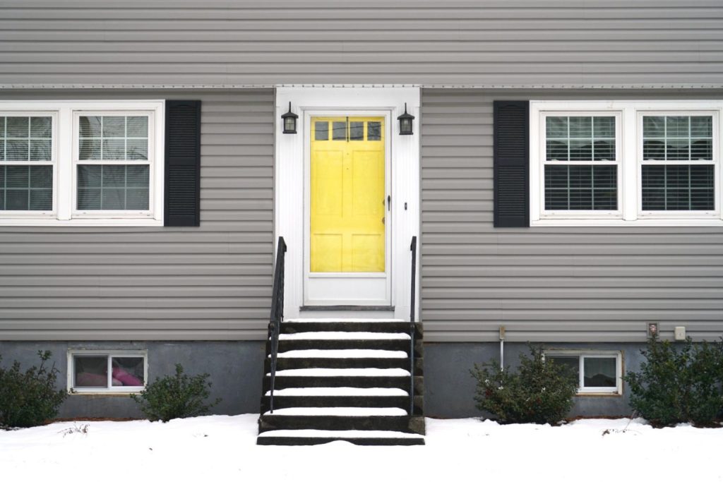 A yellow front door with a glass-panelled storm door