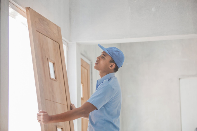 A contractor replacing an entry door to a home
