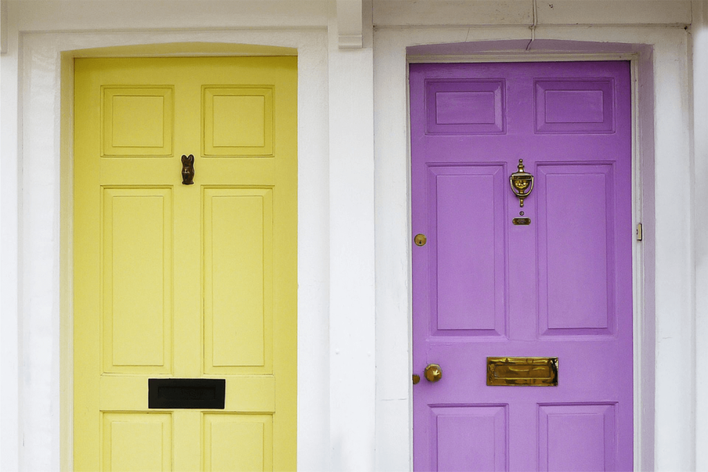 A soft yellow-coloured front door next to a bright purple front door