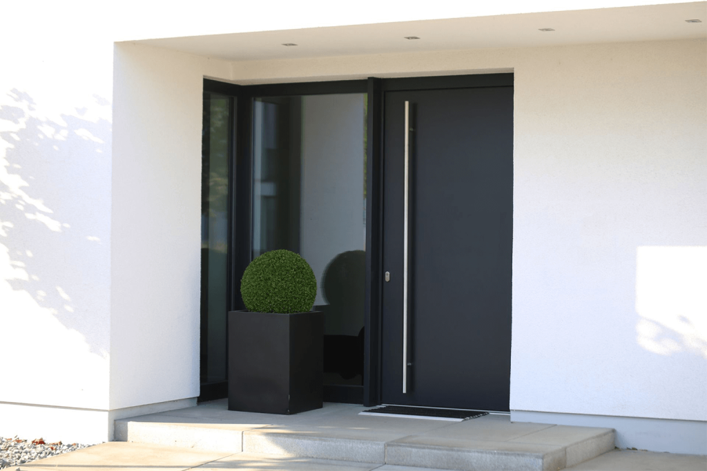 A black Scandinavian-style front door with silver hardware