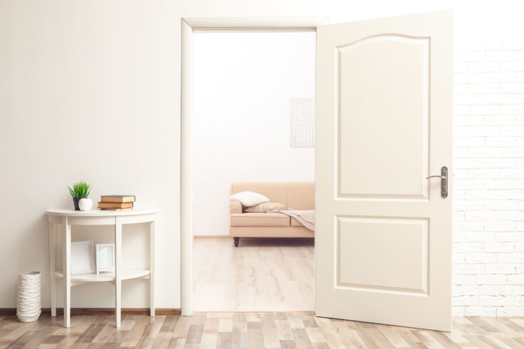 An open modern white door with a sleek, thin, minimalist-style trim 