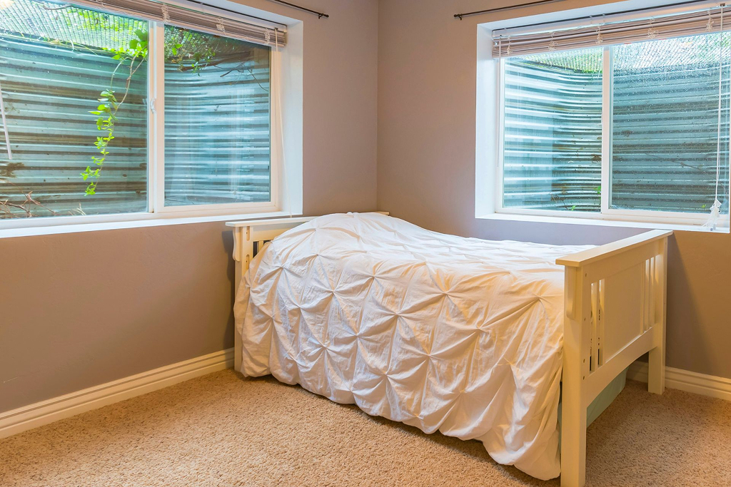 A basement bedroom with slider egress windows with window wells 