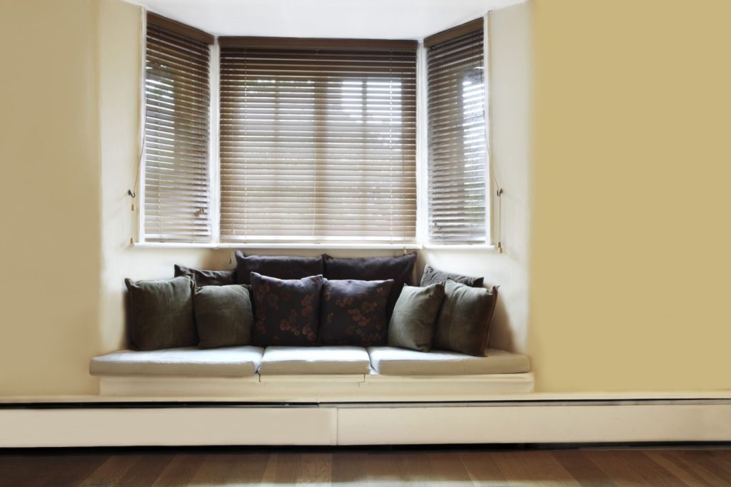 A cushioned window seat with multiple throw pillows 