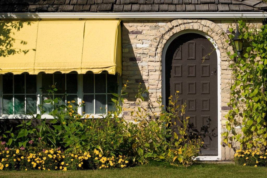 A cabin home with windows and a steel door 