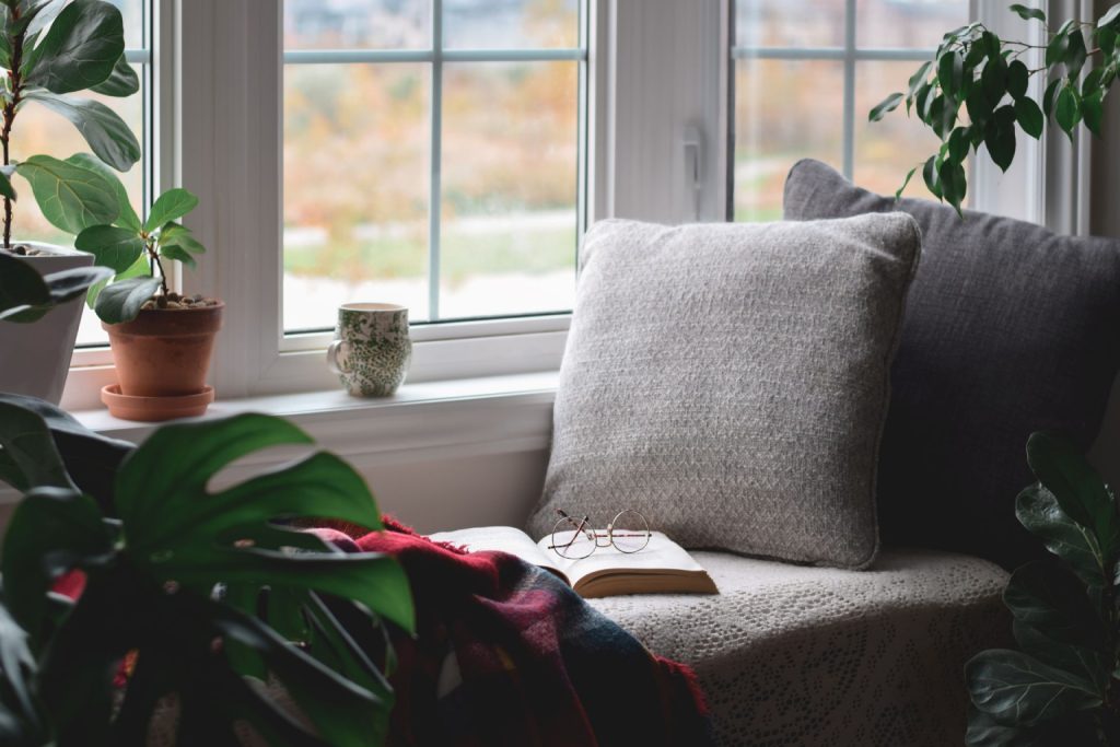  A small reading nook with multiple plants and a window seat 