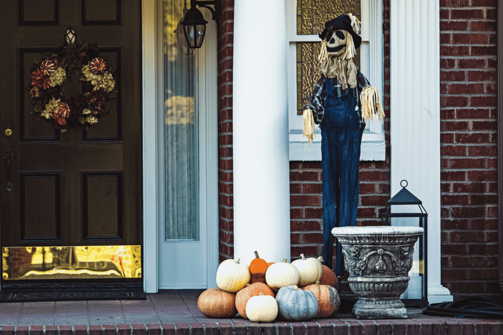 Fall wreath with metallic leaves on the door and pumpkins on the porch