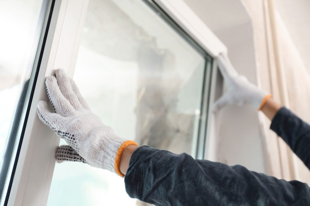 Close-up of a window installer closing a white window
