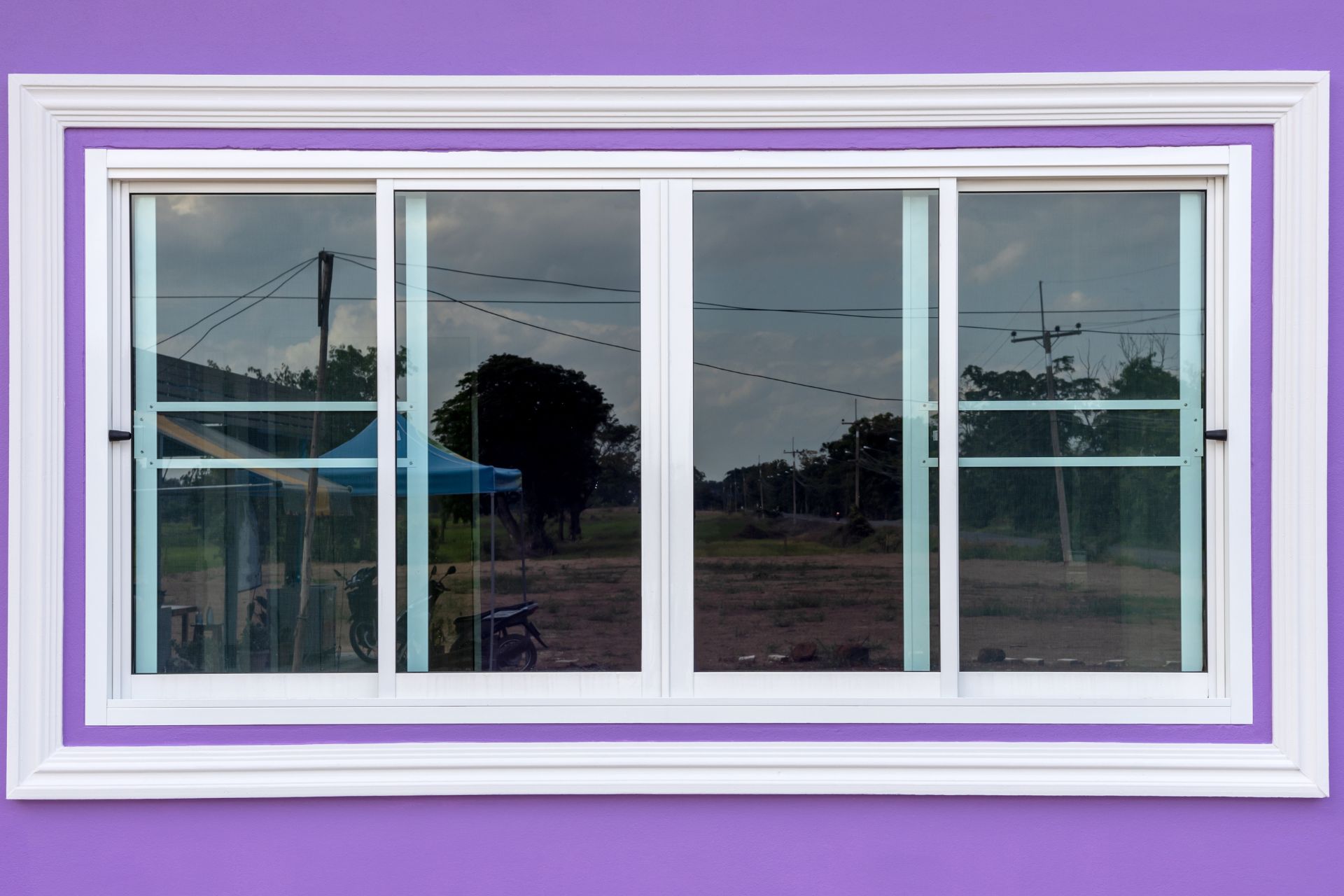 Vinyl sliding windows installed on a purple wall