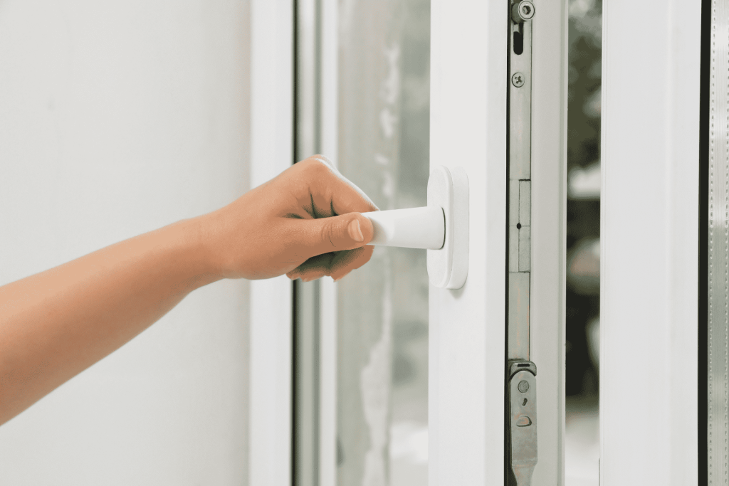 Close-up of a person using a casement window lock