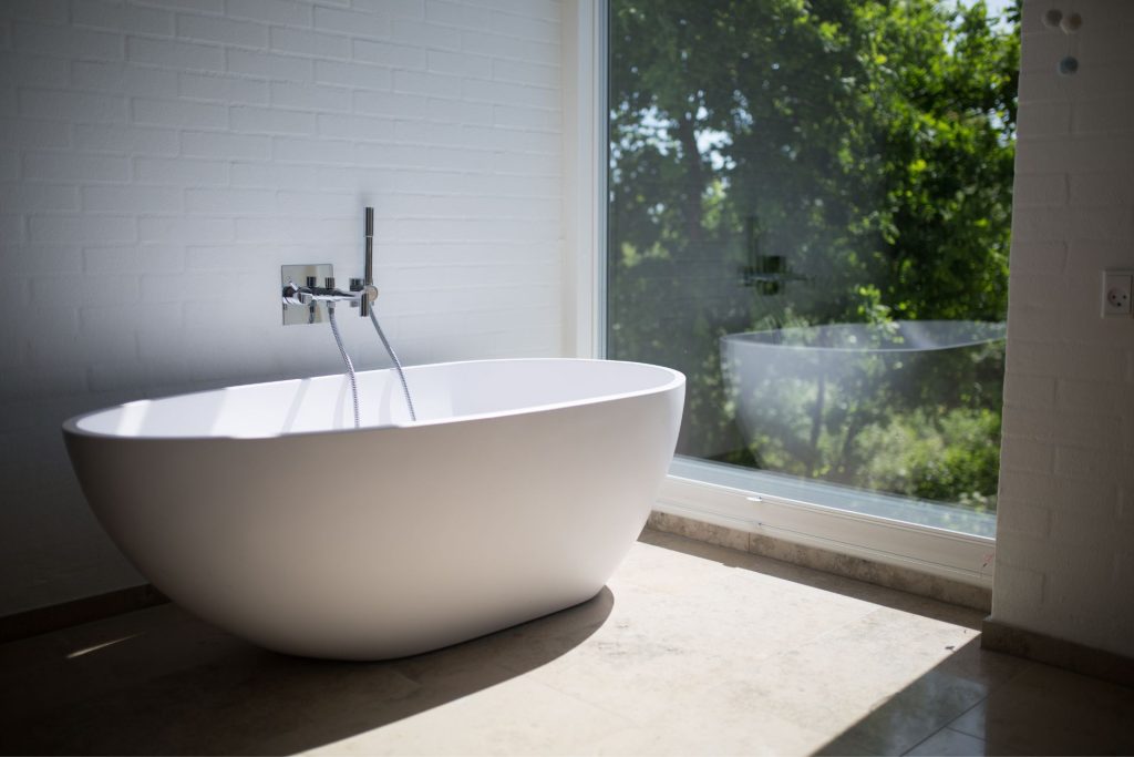 A bathtub placed in front of a large picture window