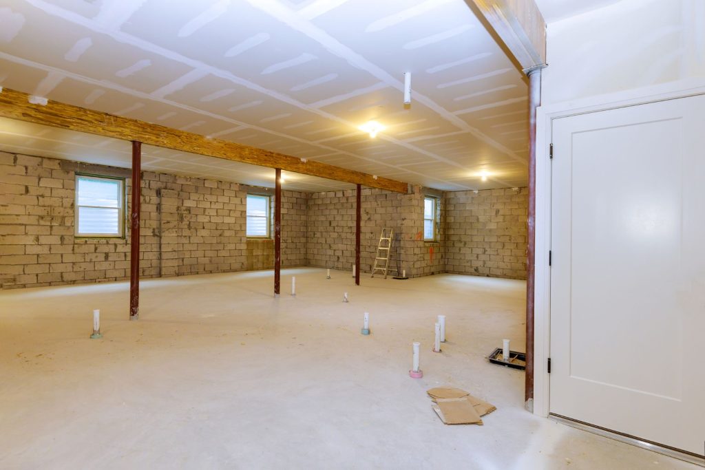 An unfinished basement with single-hung windows and window wells