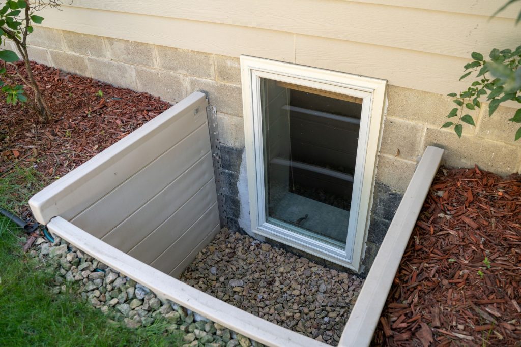 A basement egress window with a boxy well
