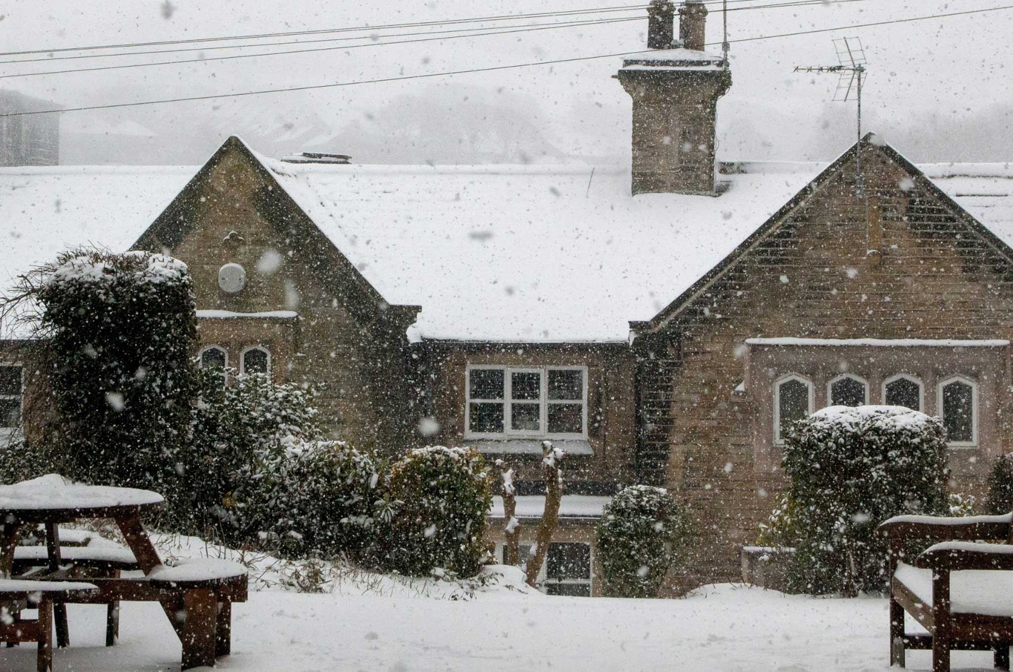 An older brick home covered in snow during the winter