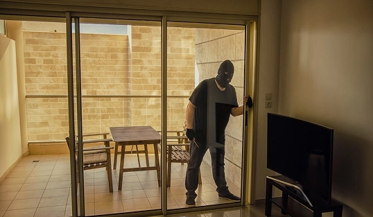 A burglar breaks into a house that needs better patio door security